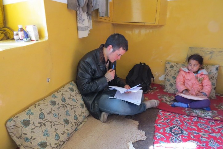 Zek conducting the survey in Zuhair's home. Zuhair's sister is looking on.